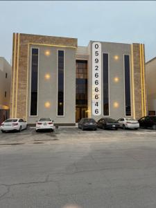 un bâtiment avec des voitures garées dans un parking dans l'établissement شقة Vip عائلية وصول ذاتي, à Hafr Al Baten