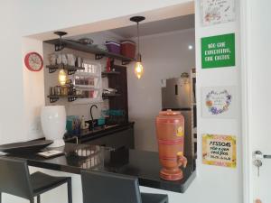 a kitchen with a counter and a table with chairs at Quarto Grande na Praia do Guaiúba! in Guarujá
