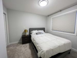 ein Schlafzimmer mit einem großen Bett und einem Fenster in der Unterkunft Havilah's Place Regina in Regina