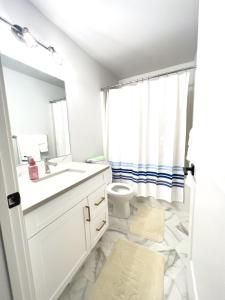 a white bathroom with a sink and a toilet at Havilah's Place Regina in Regina