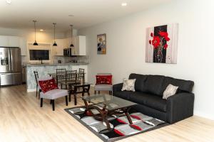 a living room with a couch and a table and a kitchen at Havilah's Place Regina in Regina +13 photos