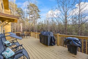 a wooden deck with chairs and tables on a house at Mountain Cabin Fireplace Views Fire Pit in Sautee Nacoochee