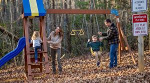 una famiglia che gioca in un parco giochi nel bosco di Mountain Cabin Fireplace Views Fire Pit a Sautee Nacoochee