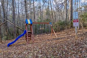 un parco giochi nel bosco con un'altalena di Mountain Cabin Fireplace Views Fire Pit a Sautee Nacoochee