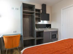 a small kitchen with a sink and a bed in a room at Thorpe Lodge Hotel in Peterborough