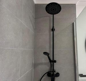 a shower with a black shower head in a bathroom at Next Door in Punta Arenas +9 photos