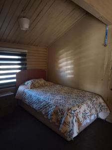een slaapkamer met een bed in een kamer met een raam bij Lago Chelenko in Chile Chico