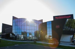duży szklany budynek z promieniami słońca w obiekcie Hotel Exclusive President w mieście Morančani