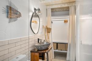 een badkamer met een wastafel en een spiegel bij El Jable Rentals in Arrieta +113 foto's