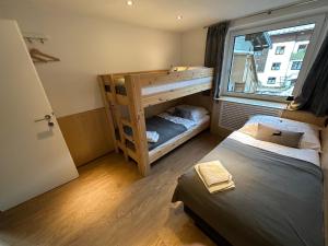 une chambre avec deux lits superposés et une fenêtre dans l'établissement Haus Dienten Apartments am Hochkoenig, à Dienten am Hochkönig