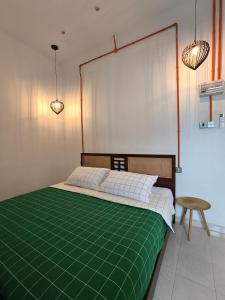 a bedroom with a bed with a green blanket at Tamu Beradu Seaview Private Pool Villa in Dungun