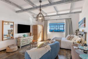 een woonkamer met een blauwe bank en een tv bij El Jable Rentals in Arrieta