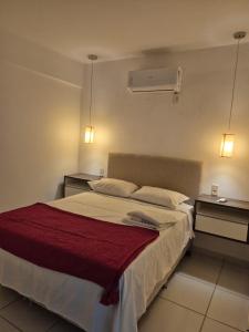 een slaapkamer met een groot bed met twee nachtkastjes bij Apartamento com suite in Parnamirim