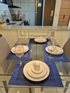 een tafel met borden en wijnglazen erop bij Apartamento com suite in Parnamirim