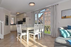 a kitchen and living room with a table and chairs at Gartenweg 3d in Tinnum
