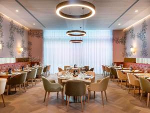 een restaurant met tafels en stoelen in een kamer bij Mövenpick Hotel Stuttgart Messe & Congress in Stuttgart