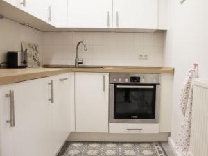een keuken met witte kasten en een spoelbak bij Ferienloft am Marktplatz - ABC609 in Wismar