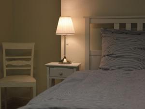 een slaapkamer met een bed met een lamp en een stoel bij Ferienloft am Marktplatz - ABC609 in Wismar