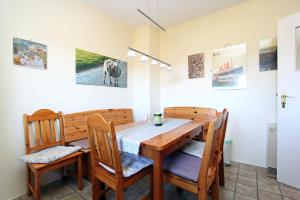 ein Esszimmer mit einem Holztisch und Stühlen in der Unterkunft Silbermöwe in Hörnum