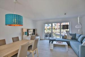 a living room with a blue couch and a table at City Marina, CM24b in Cuxhaven