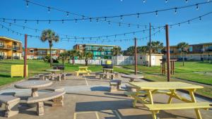 eine Gruppe von Picknicktischen und Bänken in einem Park in der Unterkunft 2 Units Beach Boardwalk Pool Pickleball Tennis Island Retreat Complex in Port Aransas