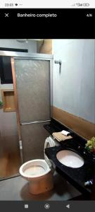 a bathroom with a toilet and a sink and a shower at Casa de Praia Beta Simão in Praia Grande