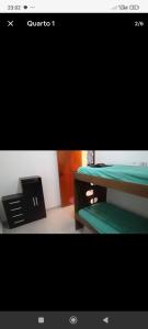 a picture of a room with a desk and a tv at Casa de Praia Beta Simão in Praia Grande