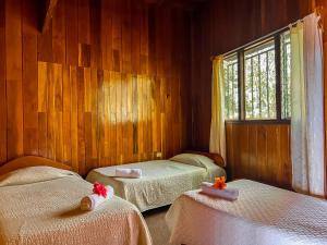 una camera da letto con due letti e una finestra di Hotel El Atardecer a Monteverde Costa Rica
