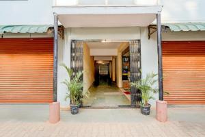 a building with orange garage doors and two potted plants at Collection O Electronic City in Bangalore