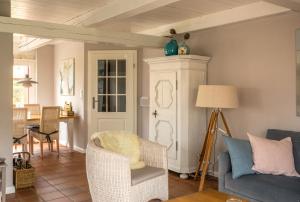 a living room with a couch and a chair at Foftein in Borgsum +13 photos