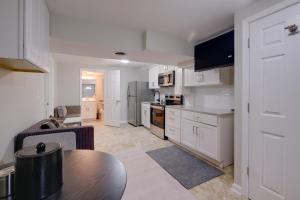 a kitchen with white cabinets and a table in a room at Work & Explore, Cozy Unit 5 Mi to UMD! in Lanham