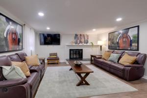 a living room with brown leather couches and a fireplace at Great for Gatherings! Modern Lanham Duplex in Lanham