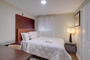 a bedroom with a white bed with a table and a desk at Great for Gatherings! Modern Lanham Duplex in Lanham