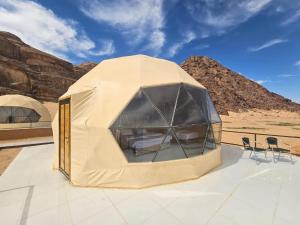 een tent op een dak met stoelen in de woestijn bij Desert Stars Bubble Camp Wadi Rum in Wadi Rum +15 foto's