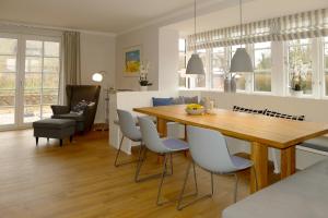 a kitchen and dining room with a wooden table and chairs at Simons Hüs in Oldsum
