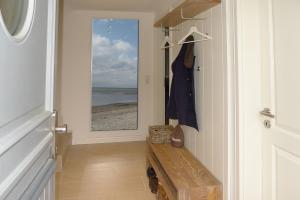 a hallway with a door with a bench and a window at Simons Hüs in Oldsum