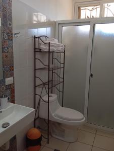 bagno con servizi igienici e appendiabiti con asciugamani. di Casa Miranda - Retalhuleu a Retalhuleu