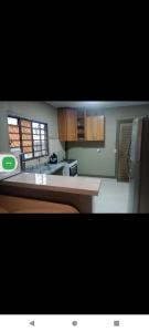 een keuken met houten kasten en een koelkast bij quarto com colchao chao in Chapada dos Guimarães