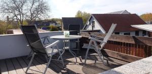 patio con 3 sedie e tavolo sul tetto di Ferienhaus "Trojan" a Zierow