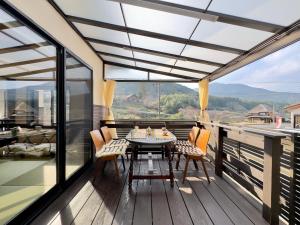 een terras met een tafel en stoelen op een dek bij IMARI HOUSE shachihoko イマリハウス しゃちほこ in Imari