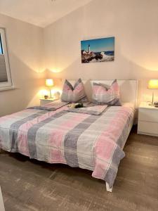 a bedroom with a large bed with two tables and two lamps at Ferienhaus Schlossblick - ABC236 in Zierow