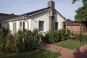 a house with trees and a swing in the yard at Ferienhaus Schlossblick - ABC236 in Zierow +1 photo