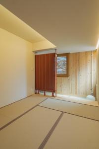 een lege kamer met een raam en een tapijt bij Peanuts Nest in Nagano