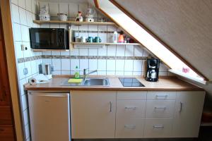 a small kitchen with a sink and a microwave at Lachmöwe in Hörnum
