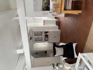 un piccolo bagno con armadi bianchi e lavandino di Hus Mewes a Goting