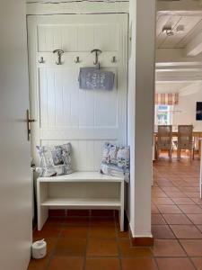 una panca bianca in un corridoio con una sala da pranzo di Hus Mewes a Goting