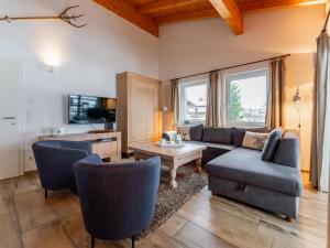 een woonkamer met een bank, stoelen en een tafel bij Salzach Lodge in Piesendorf