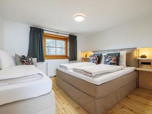two twin beds in a room with a window at Tirola Hütte in Alpbach