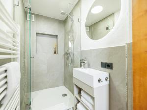 a white bathroom with a sink and a shower at Tirola Hütte in Alpbach