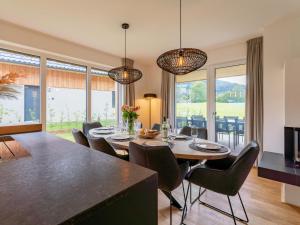 una sala da pranzo con tavolo, sedie e finestre di Mountain Chalet Alpinchique a Sankt Lorenzen ob Murau